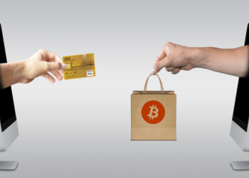Two hands coming out of computer screens. One holds a credit card and the other holds a bag with a bitcoin logo on it. They're about to exchange it. Showing how Lolli works