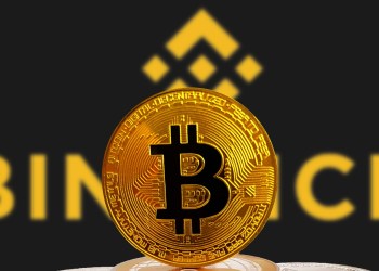 Picture of a bitcoin in front of the binance logo with binance written behind it