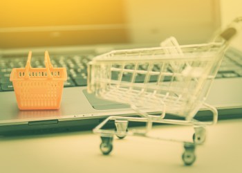 Picture of a shopping cart and basket next to a computer