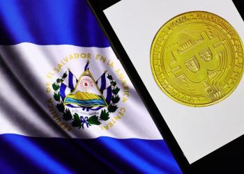 Picture of El Salvador flag with a mobile phone showing a bitcoin next to it