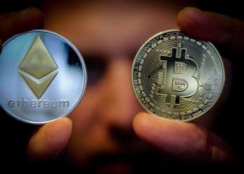 Picture of two hands holding a bitcoin and an ethereum coin