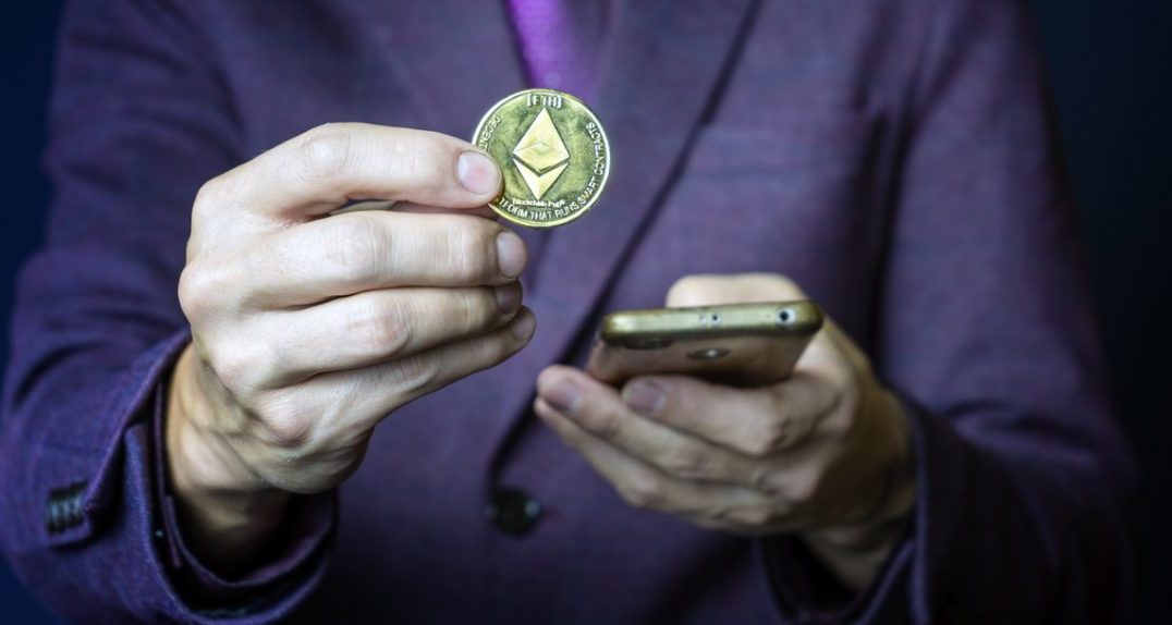 Hand holding an Ethereum coin