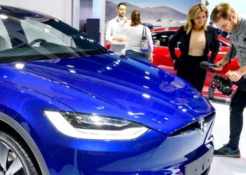 Picture of people around a Tesla EV