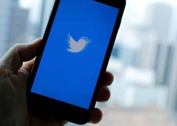 Hand holding mobile phone with Twitter open