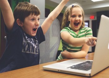 the merge, two children in front of a computer