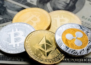 Crypto Coins Bitcoin, Ethereum and Ripple close-up on 100 American Dollars bank notes.