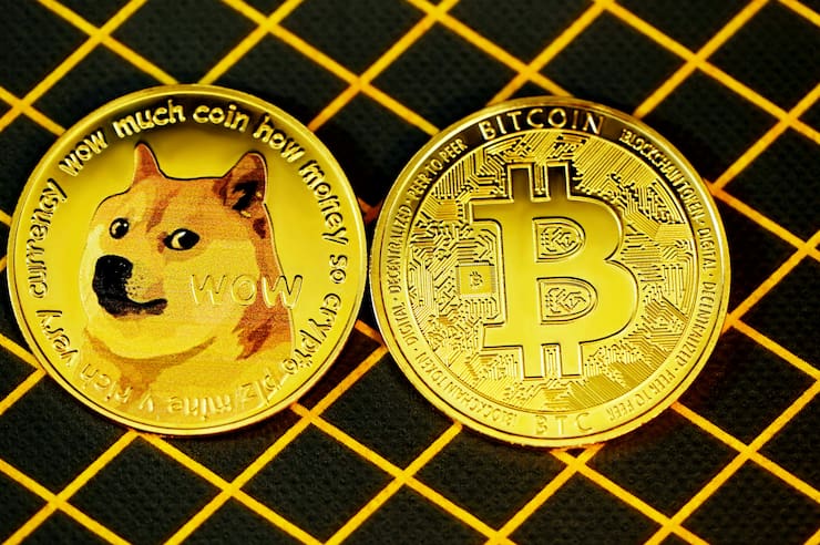 An image showing a Dogecoin and a Bitcoin placed side by side.